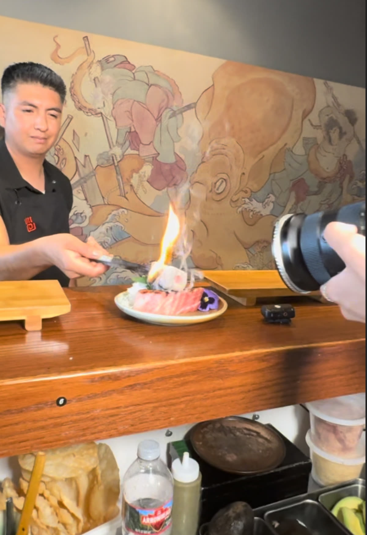 Chef torching sashimi at the counter